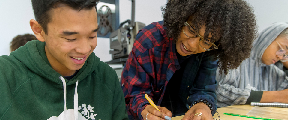 Student with instructor writing a paper