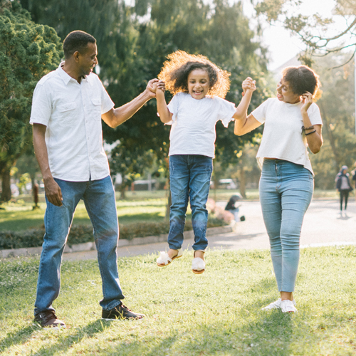 Parents jumping with a child in the park